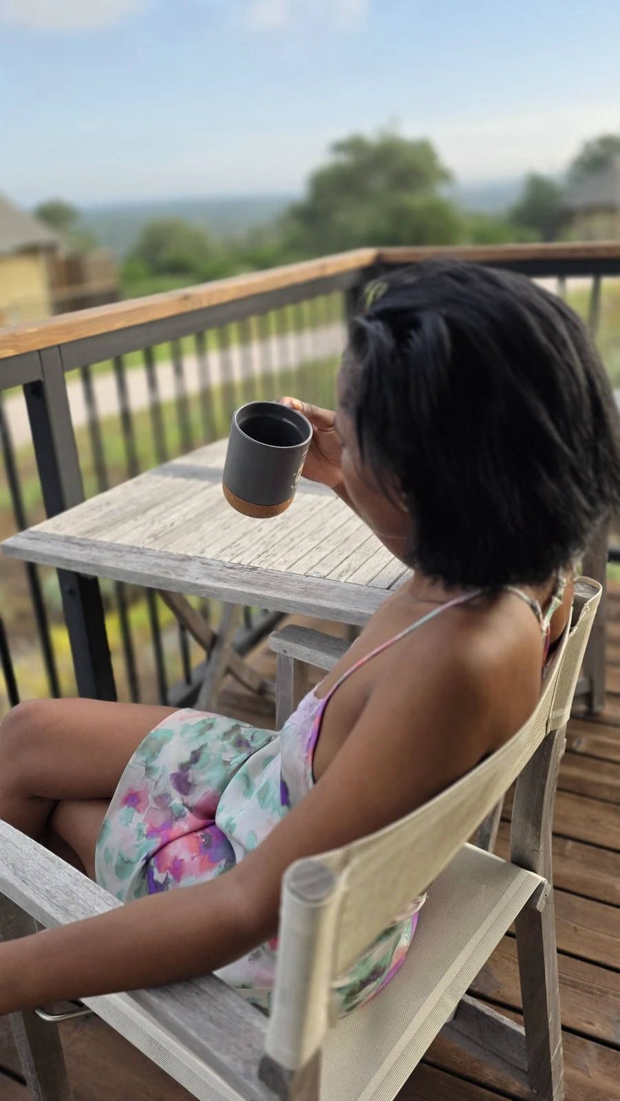 Mollyn holding a morning coffee on a sunny balcony